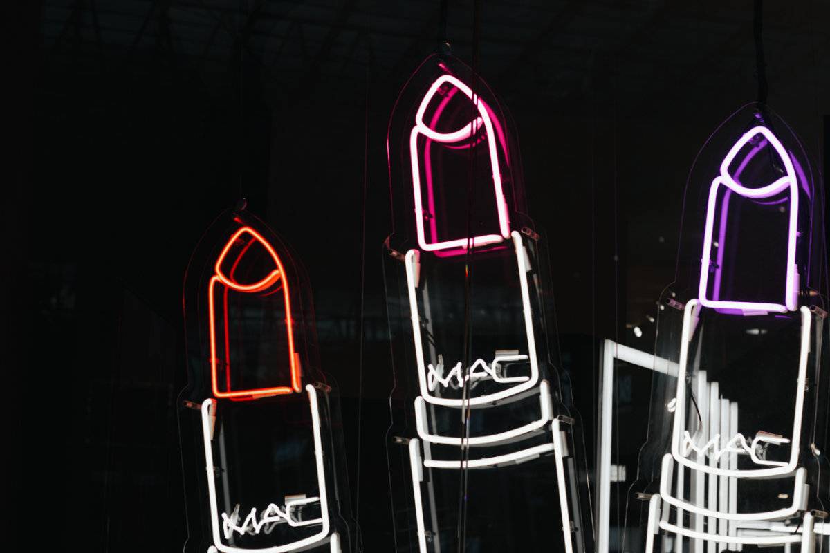 Three lipsticks in neon lights.