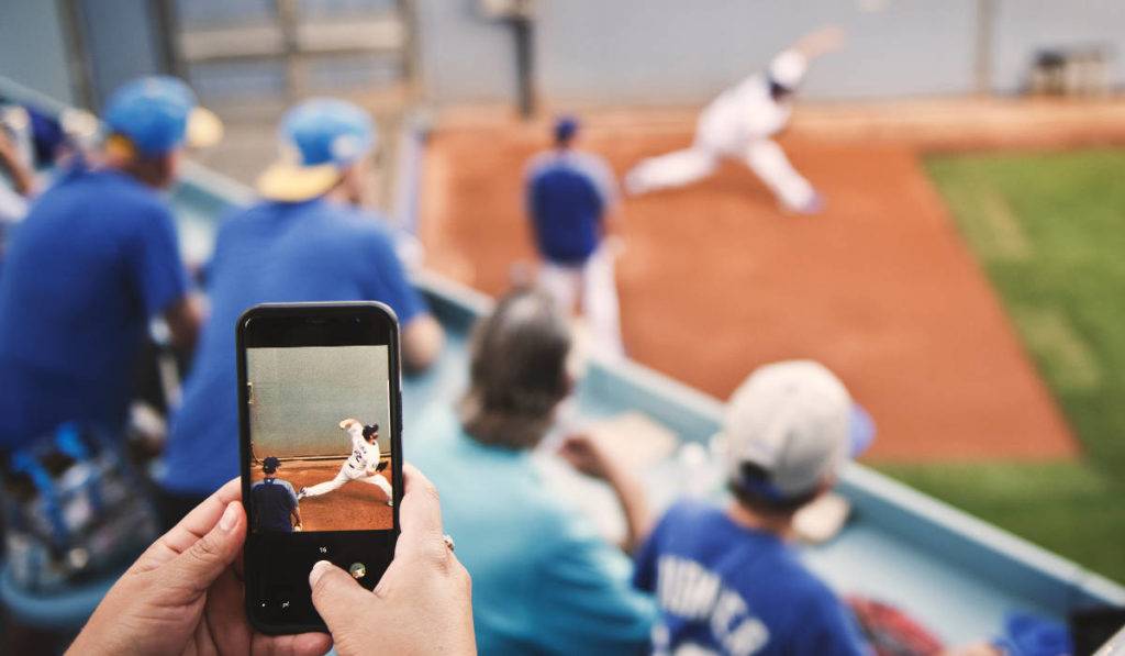 Sports social media apps - fan taking photo of baseball player from stands